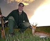 A hunter proudly displays his steenbok trophy.