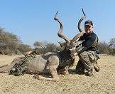 A triumphant kudu hunter holds up his trophy.