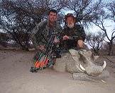 A pair of bow hunters with their warthog trophy.