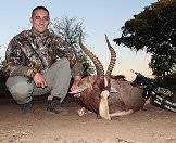 A bow hunter presents his blesbok trophy for a photograph.