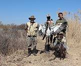 A team of wingshooters with their duck trophy and hunting dog.