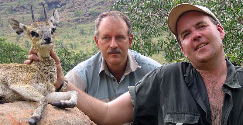 A pair of hunters sit alongside their klipspringer trophy.