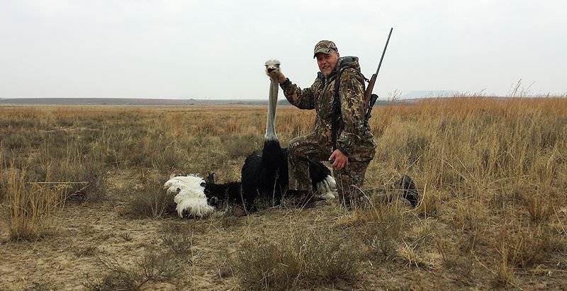 A hunter holds up his ostrich trophy for a photograph.