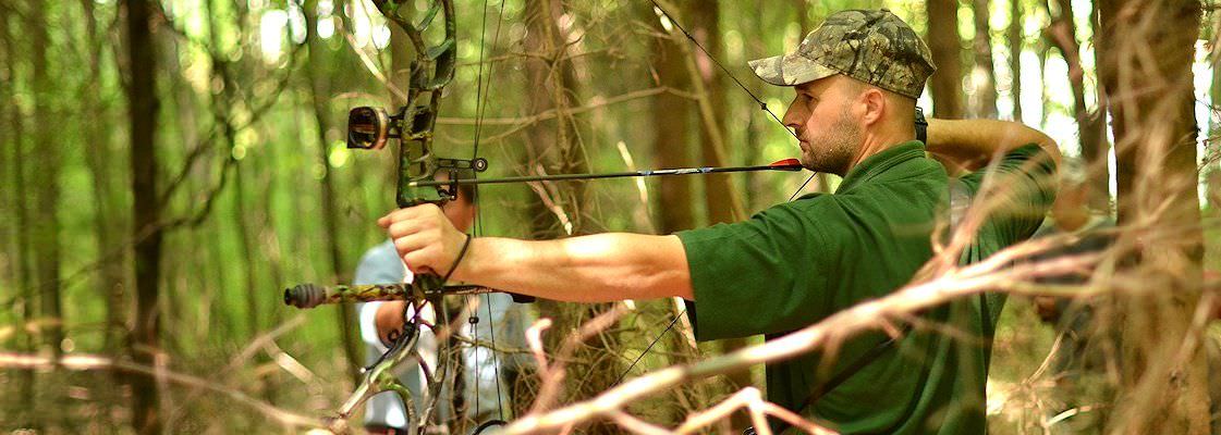 A hunter draws his bow prepares to take his shot.